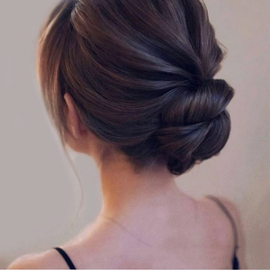 Coiffure chignon bas élégante avec épingle à cheveux en métal sur cheveux foncés