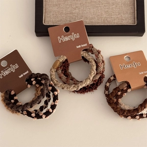 Set di elastici per capelli intrecciati marroni su cartoncino espositivo elegante