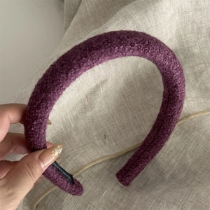 Detail view of a purple plush fleece headband with soft texture and inner black label