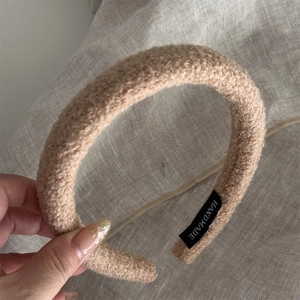 Detail showing the inner black HANDMADE label on a plush camel hairband for women
