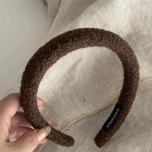 Detailed view of the dark brown plush textured headband with Hand Made label