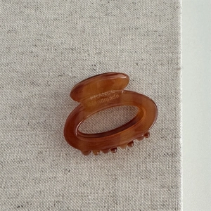 Detail view of amber acetate hair claw with France handmade engraving on linen