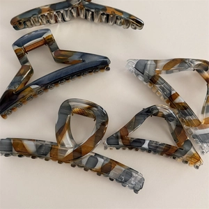 Elegant multi-colored acetate claw clips in amber and grey with premium metal springs