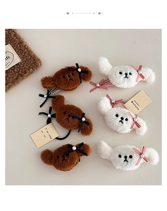 Detalle de pinzas para el pelo de perrito con lazos y perlas sobre fondo beige cálido