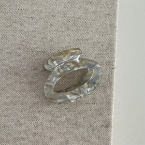 Detailed macro view of handmade marbled acetate hair claw clip with floral pattern