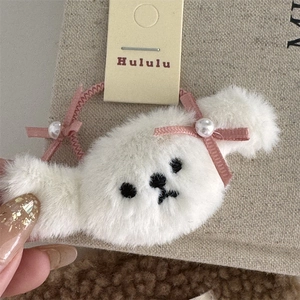 Detalle de pinza para el pelo de perrito de peluche blanco con lazos rosas y perlas