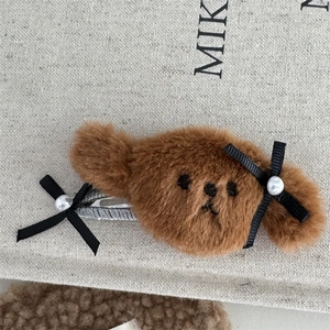 Primer plano de la horquilla de oso de peluche marrón con lazos y perlas