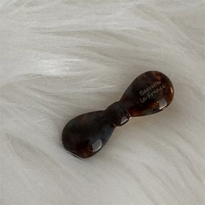 Detail of a brown acetate tortoiseshell bow hair clip with Barrette La France lettering