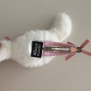 Detalle del pasador de pelo de peluche con cinta de grosgrain rosa y clip de pico de pato