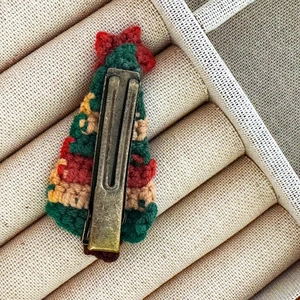 Détail de la pince crocodile en bronze et de la barrette sapin de Noël au crochet