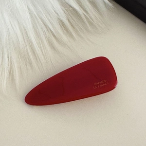 Primo piano del fermaglio a triangolo rosso scuro con incisione Barrette la France