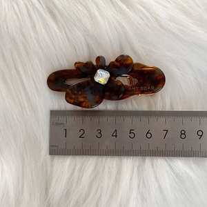 Brown tortoise shell acetate butterfly hair clip with square rhinestone on white fur
