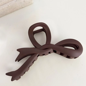 Close-up of a large dark brown matte bow hair claw clip with non-slip interlocking teeth