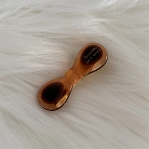 Detail of amber brown resin bow hair clip with gold Barrette La France engraving