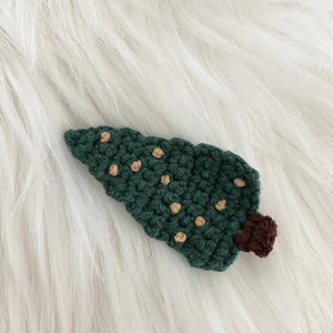 Vue macro d'une pince à cheveux sapin de Noël au crochet fait main avec texture de laine précise