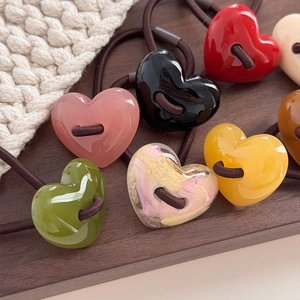 Set di elastici per capelli a cuore in resina colorata su un vassoio di legno