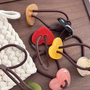 Set di elastici per capelli a cuore in resina colorata su un vassoio di legno