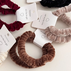 Set of 5 plush corduroy hair scrunchies in assorted warm colors on product cards