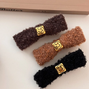 Three lamb wool hair clips in brown and black with gold smiley face metal buckle