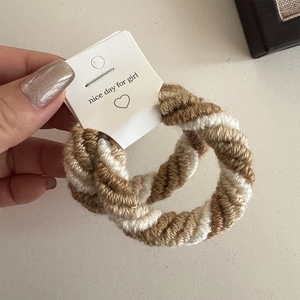 Close-up of thick coffee-colored knitted hair tie with custom branded packaging card