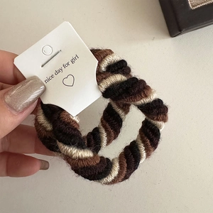 Detailed view of the thick multi-strand twisted elastic hair tie in coffee and beige tones