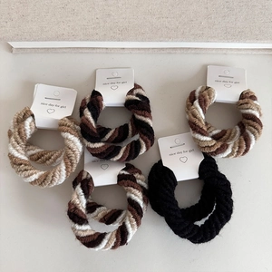 Close-up of knit spiral hair scrunchies in coffee tones on white heart display cards