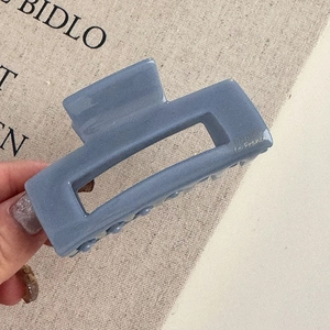 Vue détaillée d'une pince à cheveux rectangulaire bleu-gris mat avec texte La France