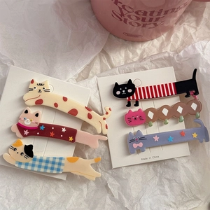 Detailed view of six cute cat-shaped hair clips in various patterns on display cards