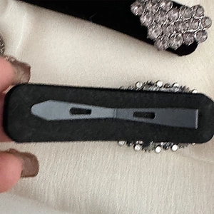 Detail showing vintage hair clips with white rhinestones and black velvet backing