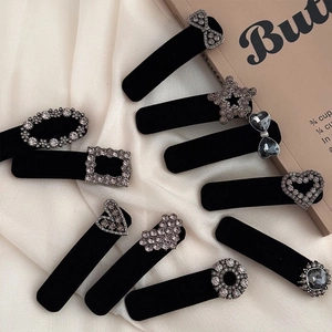Close-up of vintage black velvet hair clips with grey rhinestones and crystal details