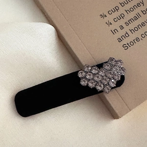 Detail of vintage velvet hair clip featuring a sparkling rhinestone heart decoration