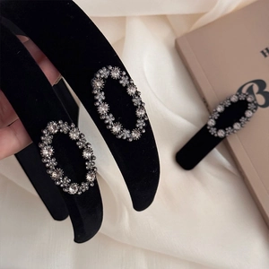 Elegant black velvet headband with oval rhinestone accents on silk background
