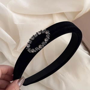 Close-up of black velvet wide headband with sparkling oval crystal rhinestone decoration