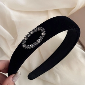 Close-up of black velvet headband with sparkling oval crystal rhinestone embellishment
