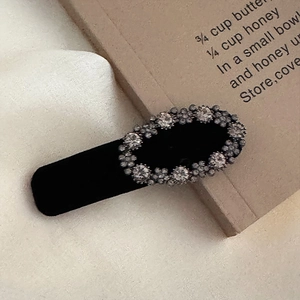 Macro detail of vintage black velvet hair clip with oval crystal rhinestones decoration