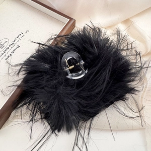 Dettaglio dell'elegante pinza per capelli nera pelosa su sfondo di seta beige