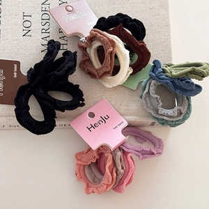 Detail of high-elasticity ruffled hair bands in multiple colors on a branded paper card