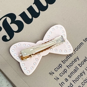 Détail de l'arrière de la pince à cheveux rose avec perles et clip crocodile doré