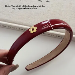 Détail montrant la largeur de 2cm du serre-tête en cuir rouge brillant avec fleur d'or