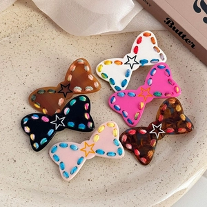 Set di sei fermagli per capelli a fiocco colorati con stelle e cuciture