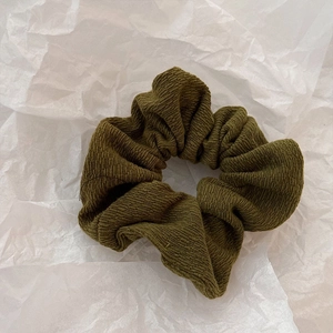 Vue détaillée de la texture tricotée vert olive et du tissu côtelé de ce chouchou chic