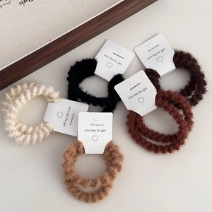 Detail of plush elastic hair ties in earth tones with soft texture and wave pattern