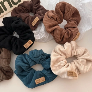 Knitted smiley face hair scrunchies set in various autumn colors with handmade leather labels