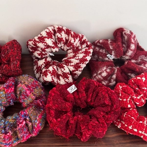Macro shot showing diverse red wool and tweed textures of the festive headbands