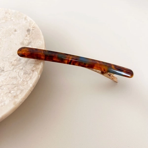 Vue détaillée de la pince à cheveux en acétate avec motif écaille et attache en métal doré