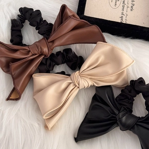 Lot de trois chouchous avec nœuds en similicuir en marron, beige et noir