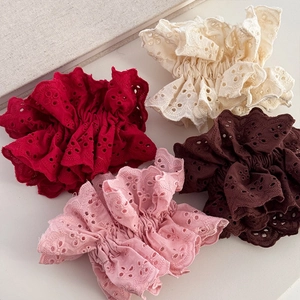 Lace embroidered oversized scrunchies in four soft colors on a beige minimalist background