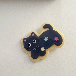 Dettaglio di un fermaglio per capelli a gatto viola con stelle e simbolo dell'infinito
