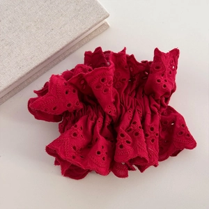 Close-up of oversized red lace scrunchie with intricate eyelet embroidery detail