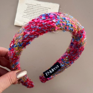 Close-up of red tweed woven headband texture with FMdrea brand label detail